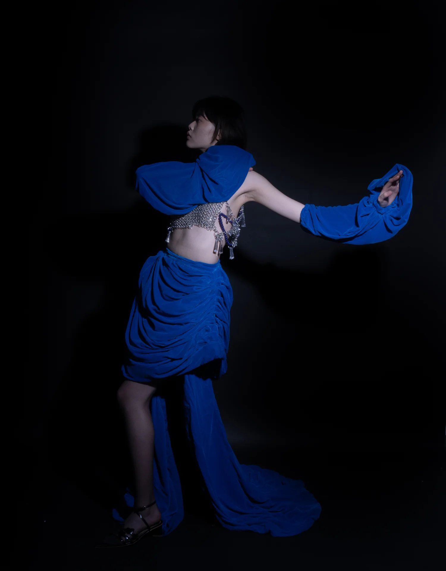 Model wearing a sculptural blue dress